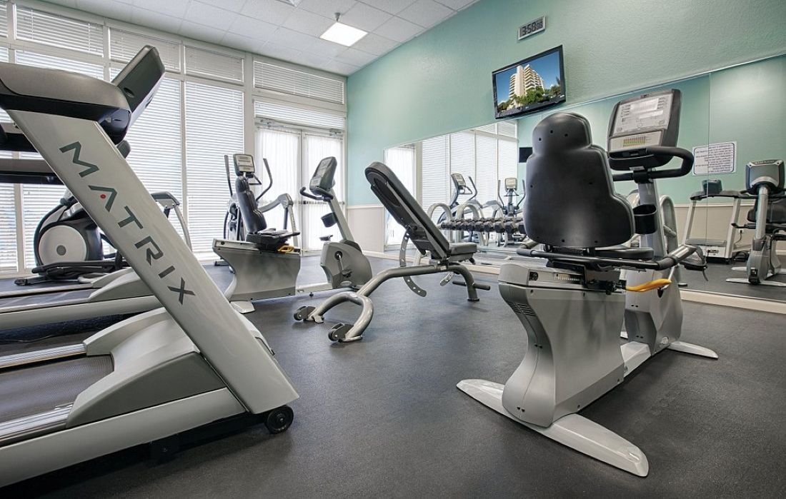 A gym with treadmills, elliptical machines, and weight machines.