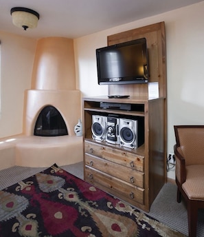 Un salon avec une cheminée, un téléviseur et un système audio.