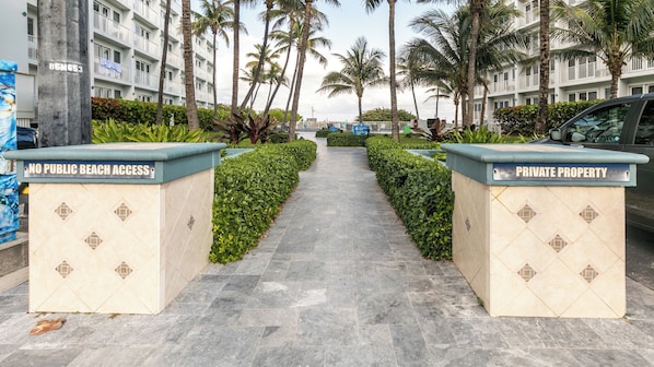 A pathway flanked by two signs indicating private property and no public beach access. - Pompano Beach | Relaxed Cabana Stay | Pool + Beach (Pompano Beach)