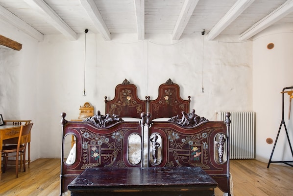 A room with a wooden bed, a wooden chair, and a radiator. - Holiday home 'Dimora Dei Frati - Wundergarten' with mountain view, Wi-Fi and air conditioning (Gratteri)