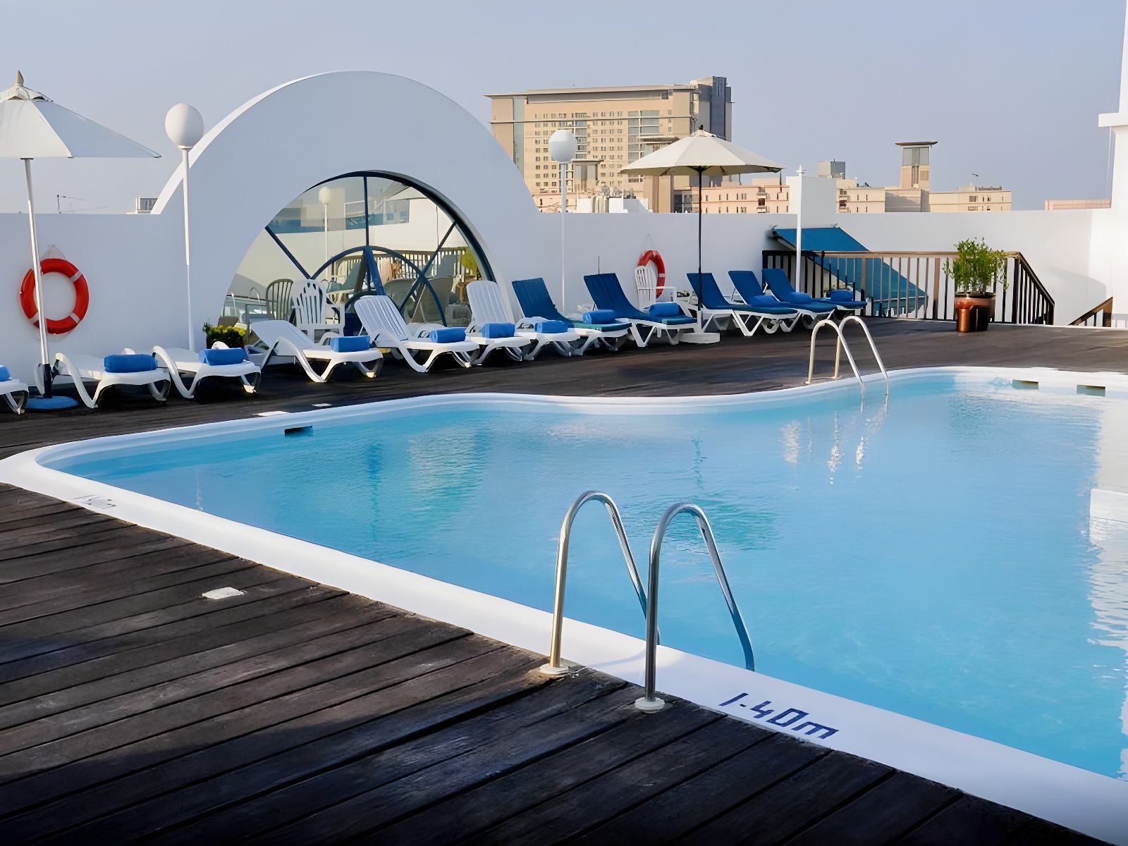 A swimming pool with a deck, lounge chairs, and a lifebuoy.