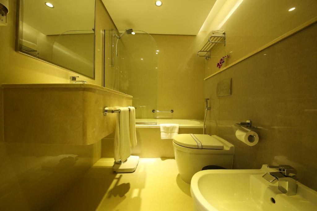 A modern bathroom with a bathtub, toilet, and sink.