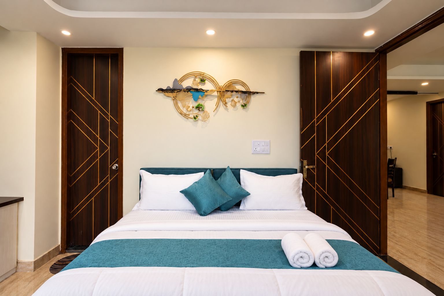 Una camera d'albergo con un letto, un'opera d'arte appesa al muro e un armadio in legno.