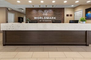 Un mostrador de recepción con el logotipo de 'WORLDMARK BY WYNDHAM' y una computadora Lenovo.