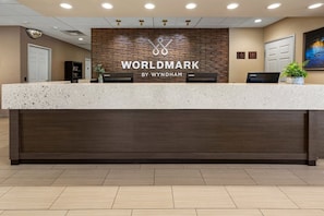 Un mostrador de recepción con el logotipo de 'WORLDMARK BY WYNDHAM' y una computadora Lenovo.