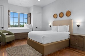 Un dormitorio con una cama grande, una silla, una mesita de noche, una lámpara de pared y una ventana con vistas.