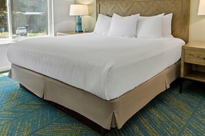 A large bed with white linens, a wooden headboard, and a blue patterned carpet. - Wolf Creek | Romantic Ski Retreat | Pool + Ski (Eden)