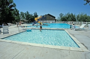 A swimming pool with a slide, lounge chairs, and a covered area. - Wolf Creek | Group Ski Retreat | Pool + Ski | 3BR Sleeps 8 (Eden)