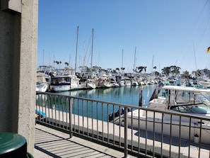 A marina with multiple boats docked, a clear sky, and a concrete structure in the foreground. - San Diego | Friends Beach & City Trip | Pool + Hot Tub | 2BR (San Diego)