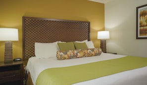 Ein Hotelzimmer mit einem großen Bett, zwei Nachttischen und einem Kopfteil mit strukturierter Musterung.