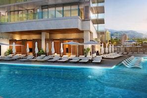 Un hotel moderno con piscina infinita en la azotea, sillones de descanso y vistas a la ciudad.