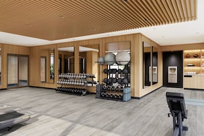 Une salle de sport équipée de matériel d’exercice, d’un point d’eau et d’un miroir.