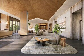 Un interior moderno con techo de madera, una recepción, una zona de estar con sofá y mesa de centro, y un ventanal con vistas.