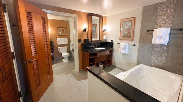 Une salle de bain moderne comprenant une baignoire, un meuble-lavabo avec un évier, des toilettes et un espace douche.