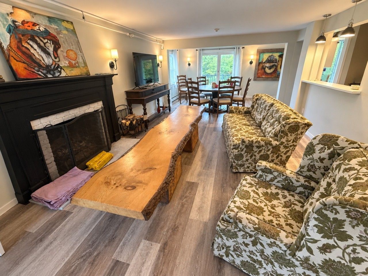 A living room with a fireplace, a wooden coffee table, a sofa, and a dining table with chairs.
