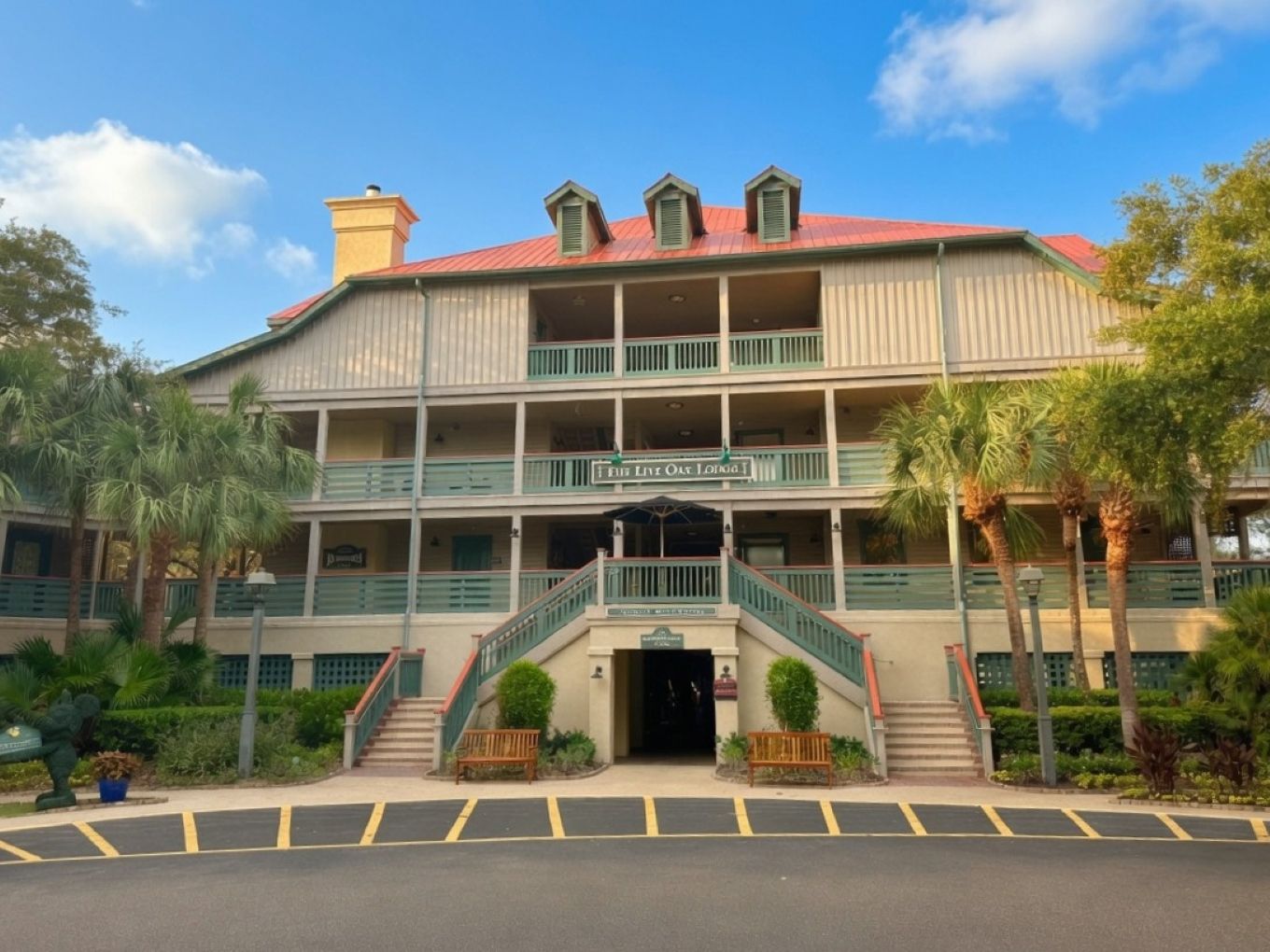A multi-story hotel with a red roof, balconies, and a sign reading 'Live Out Here.'