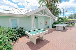 A pool table in an outdoor area with a building in the background. - Orlando | Park Trip Base Stay | Pool + Golf (Lake Buena Vista)