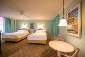 Een hotelkamer met twee bedden, een kleine tafel, een stoel, een plafondventilator en een lamp aan de muur.