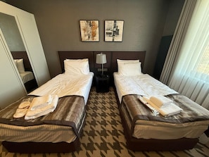 A hotel room with two single beds, a nightstand with a lamp, and two abstract paintings on the wall. - Lorent Hotel İncek (Golbasi)