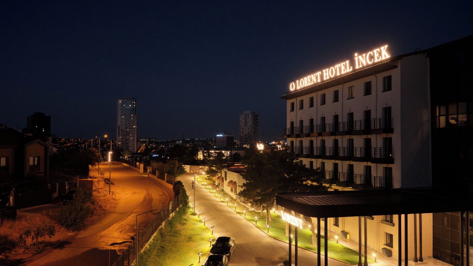 Un hotel con un letrero que dice 'LORENT HOTEL INCEK' de noche.