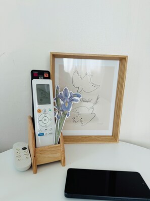 A framed artwork, a remote control, and a tablet on a white surface. -  10 Min to Hongik Univ. Station 6min to Bus Stop (Seoul)
