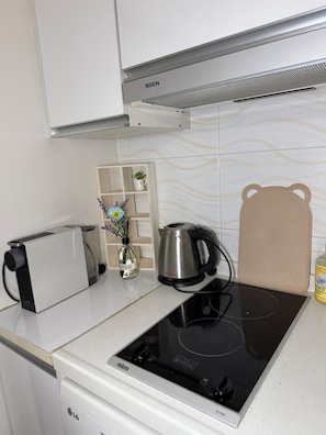 A kitchen with a built-in induction cooktop, a toaster, a kettle, and a cabinet above. -  10 Min to Hongik Univ. Station 6min to Bus Stop (Seoul)