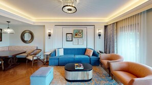 Una sala de estar moderna con un sofá azul, una mesa de centro redonda y una mesa de comedor de madera.