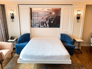 A hotel room with a large bed, two blue sofas, a small table, a chair, and a painting on the wall. - Orlando | Family Riviera Retreat | Pool + Resort | 2BR (Lake Buena Vista)
