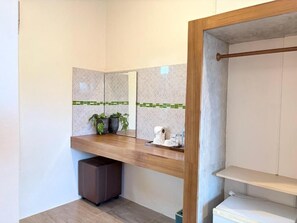Une salle de bain avec un meuble-lavabo en bois, un miroir et un porte-serviettes.