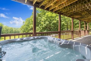 A hot tub under a wooden pergola with a view of a green landscape. - Branson | Group Ozarks Retreat | Pools + Fitness | 3BR • Sleeps 8 (Ridgedale)