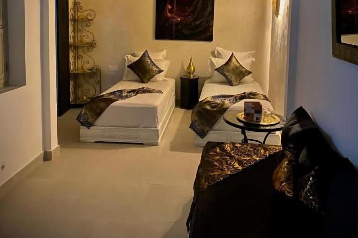 A bedroom with a bed, bedside table, and a wall-mounted artwork.