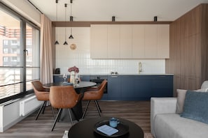 Eine moderne Küche mit Essbereich, ausgestattet mit einem runden Tisch, Stühlen und Blick auf die Stadt.