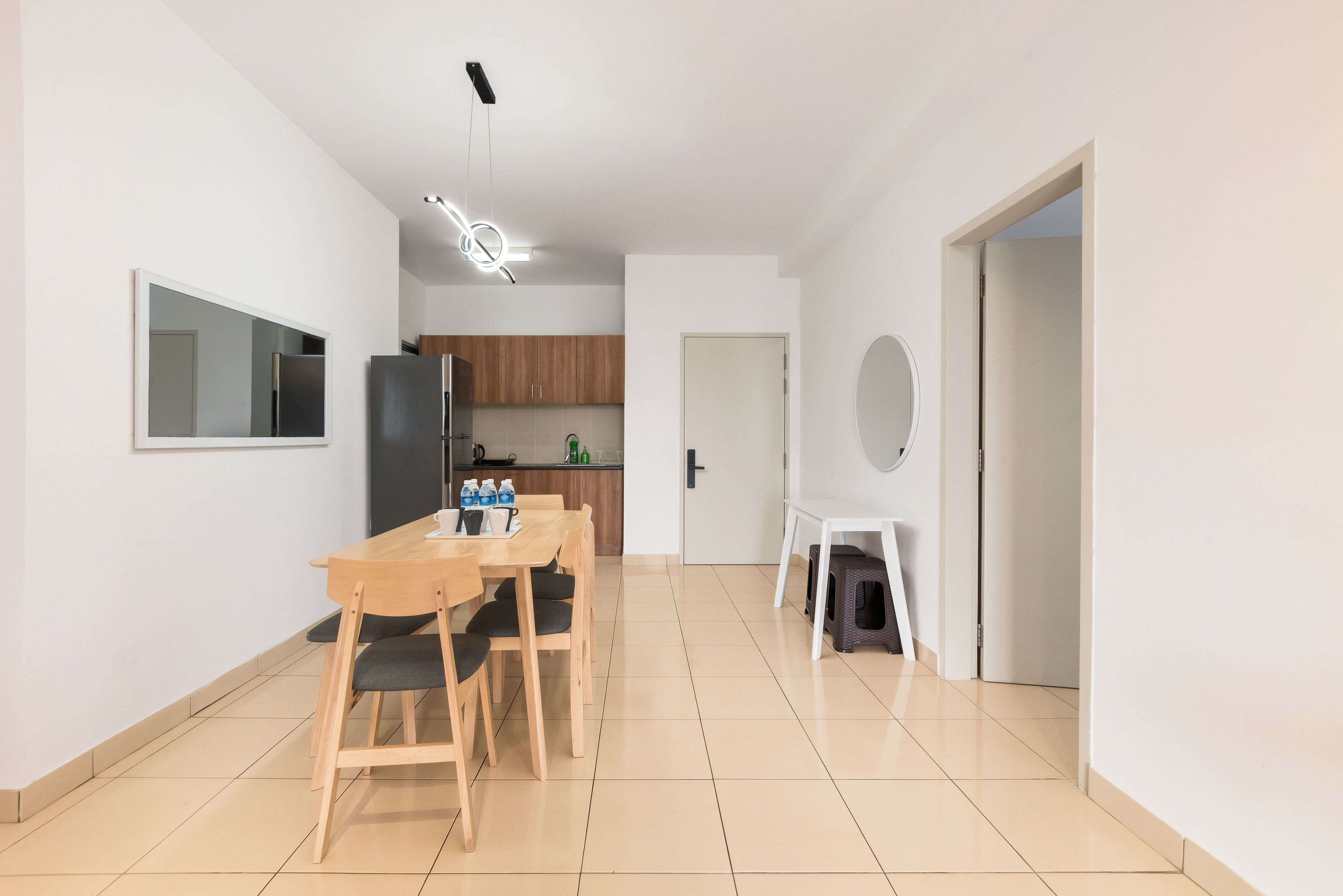 A modern kitchen with a refrigerator, stove, and wooden cabinets.