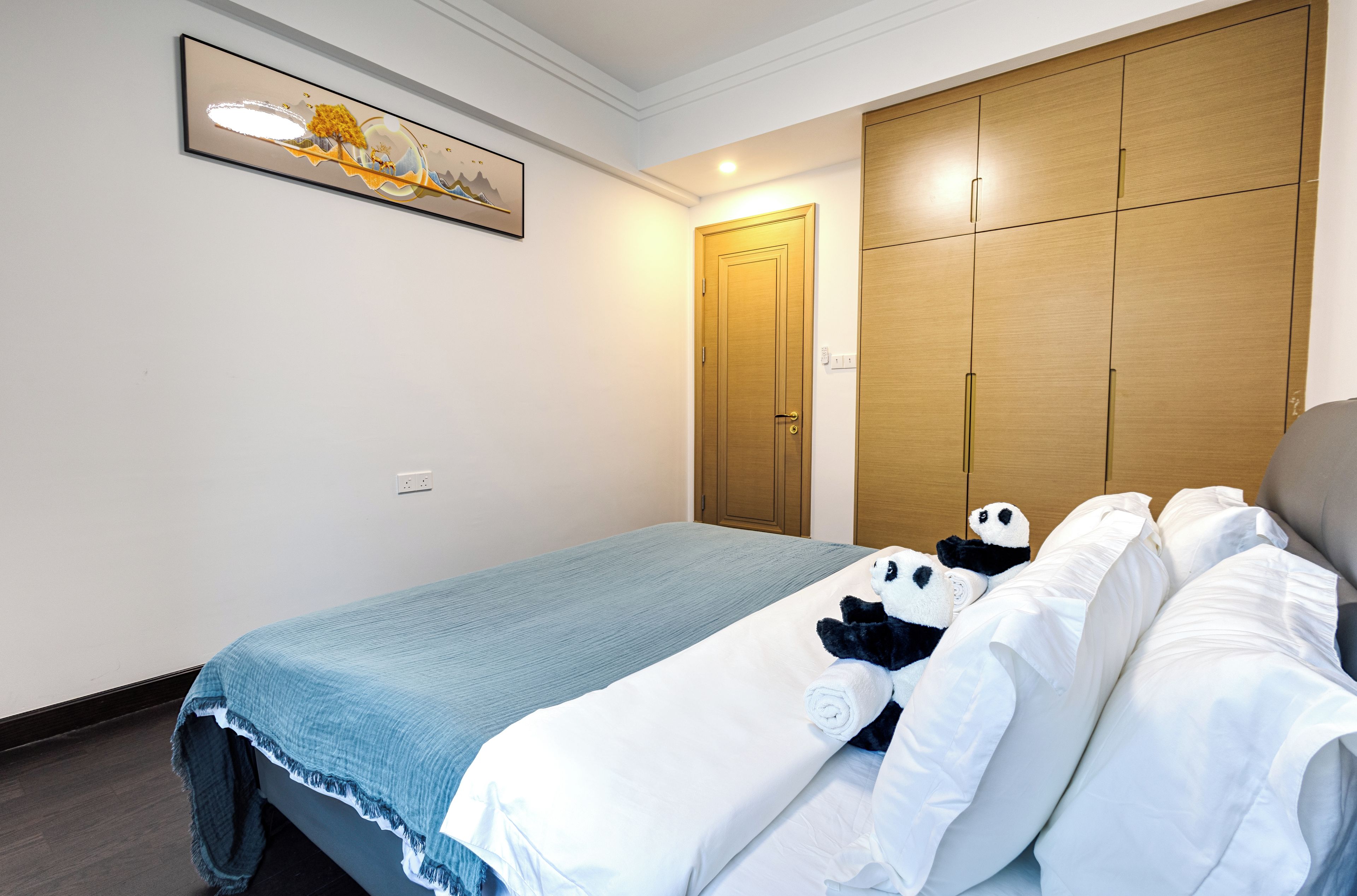 Una camera d'albergo con un letto, un armadio e un quadro appeso al muro.