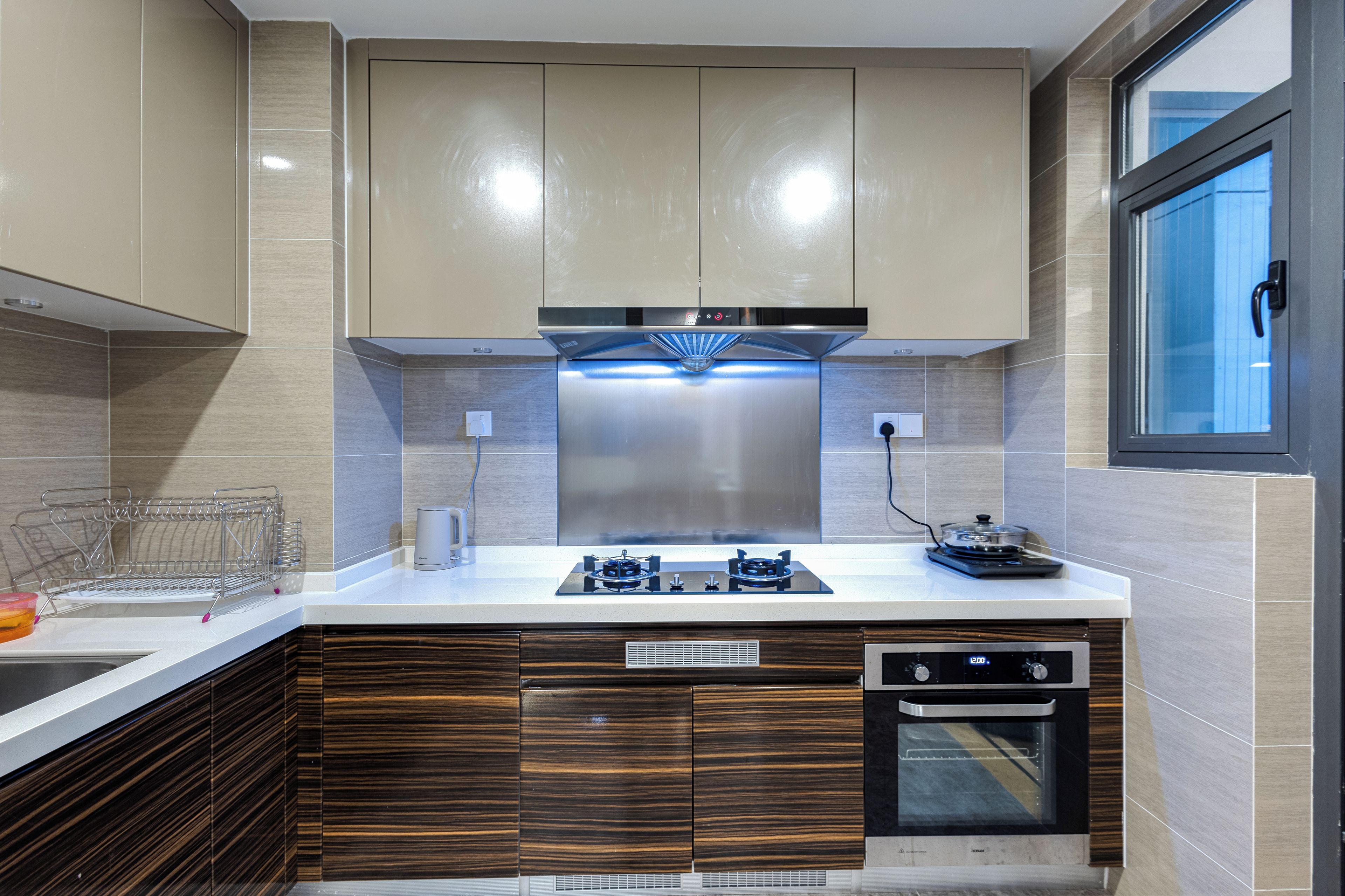 A modern kitchen with a built-in stove, oven, and a window with a view.