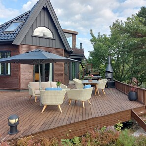 Una terrazza con mobili da esterno, un barbecue e un camino.