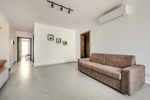 Een moderne woonkamer met een bank, een gang en een deur.