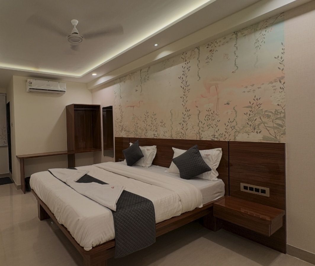 Un dormitorio moderno con una cama grande, mesitas de noche, un equipo de aire acondicionado y un ventilador de techo.