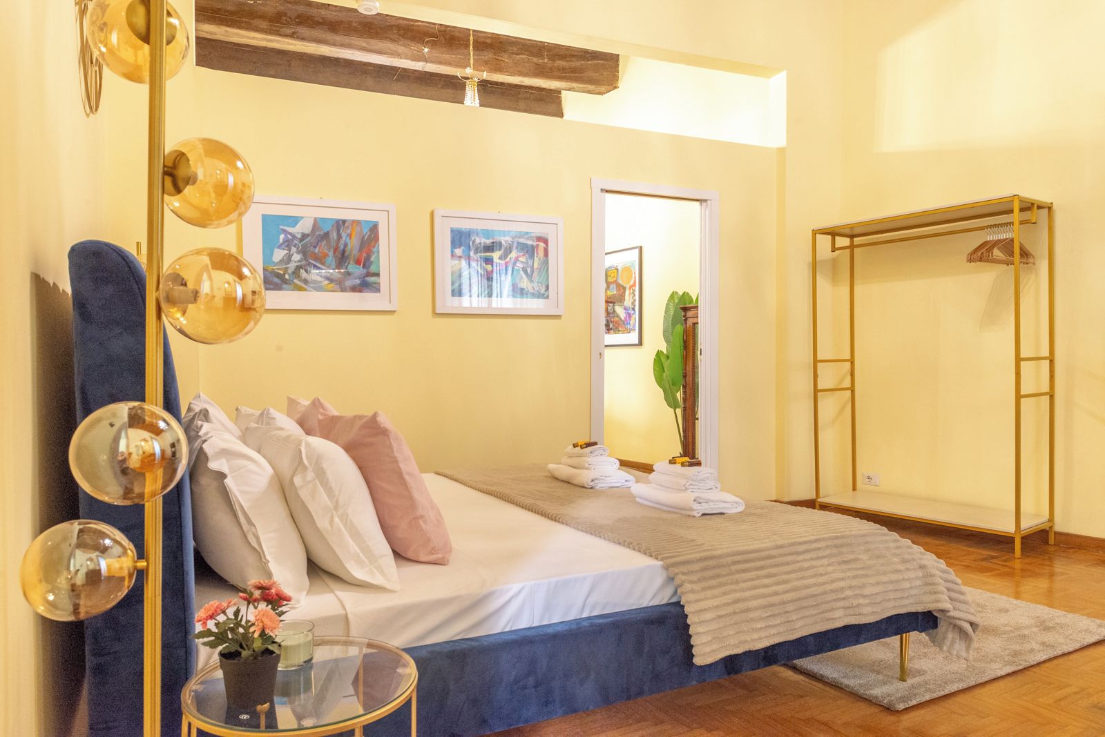 A bedroom with a bed, a bedside table, a mirror, and a wardrobe.