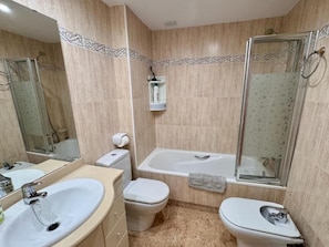 Casa de banho com banheira, sanita e lavatório.