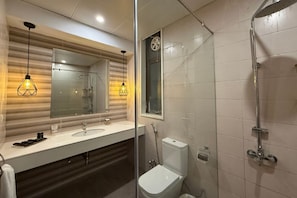 A modern bathroom with a glass shower enclosure, a large mirror, and a white sink. - The Sarai Hotel & Resorts (Naran)
