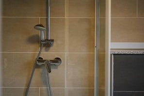 A shower with a handheld showerhead and a wall-mounted faucet. - Nockventure Vacation Home in the Nockberge Mountains by WÖRTHWHILE (Gnesau)