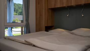Ein Schlafzimmer mit einem Bett, einem Holzkopfende und einem Fenster mit Vorhängen.