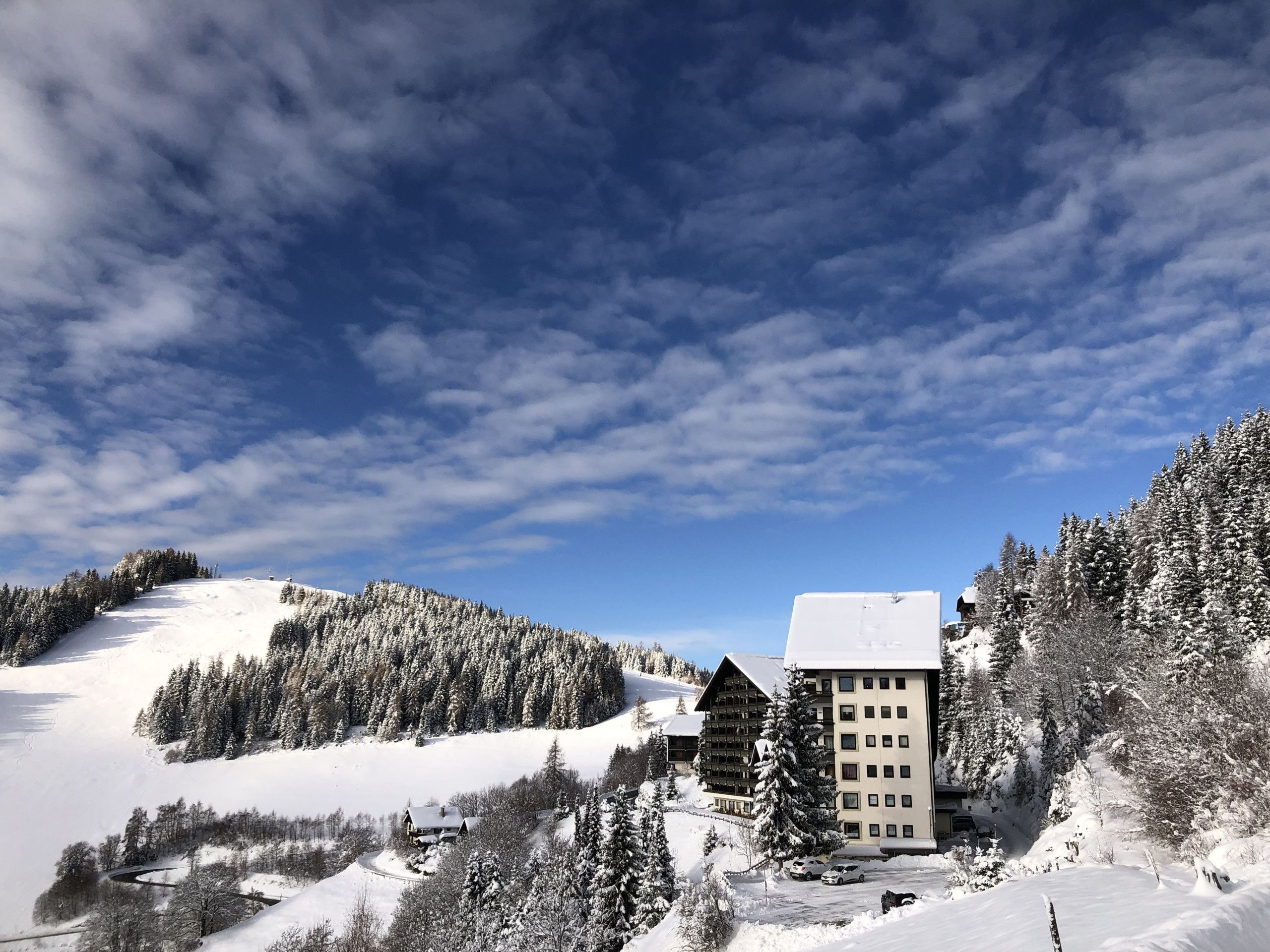 Paesaggio montano innevato con un lodge e un edificio con molte finestre.
