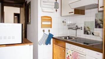 A modern kitchen with white cabinetry, a Bosch dishwasher, a sink, and an oven.