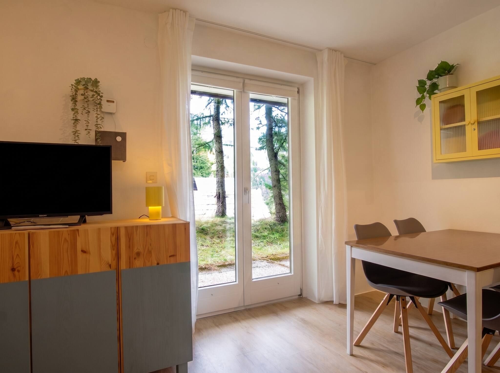 Eine moderne Küche mit einer Holzauslage, einem Fernseher und einem Essbereich mit Tisch und Stühlen.