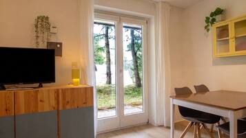 Eine moderne Küche mit einer Holzauslage, einem Fernseher und einem Essbereich mit Tisch und Stühlen.