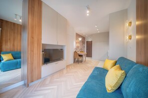 Uma sala de estar moderna com sofá, mesa de jantar e área de cozinha.