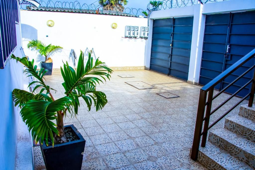 A courtyard with a tiled floor, a staircase, and potted plants.