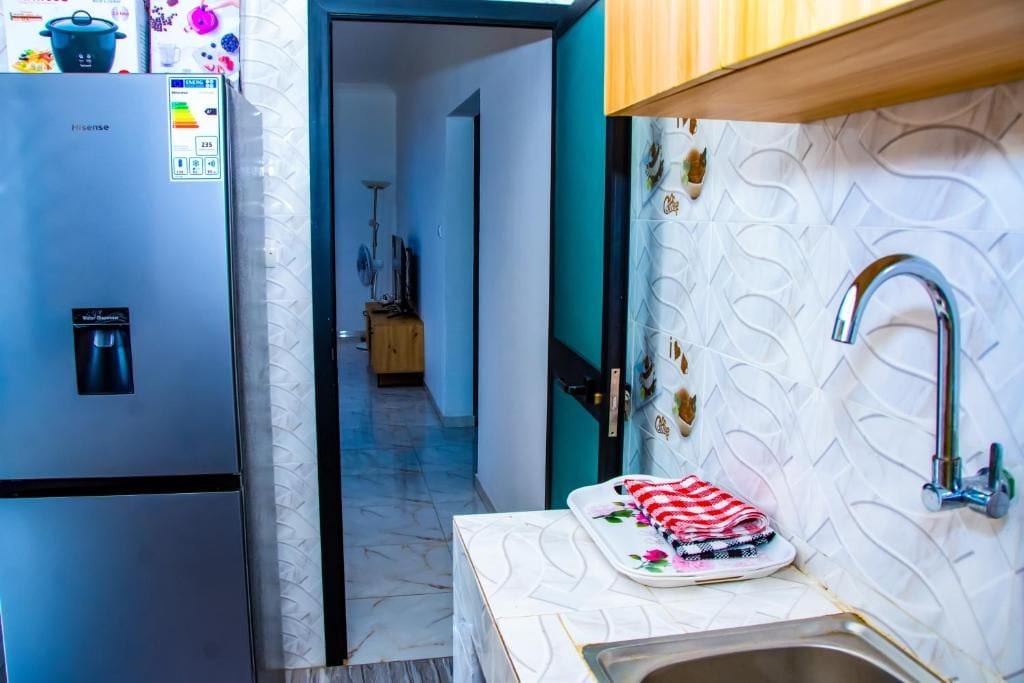 A compact kitchen with a refrigerator, a sink, and a countertop.